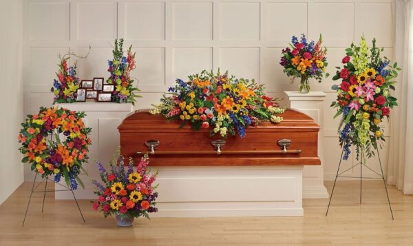 A wooden casket with flowers on top of it.