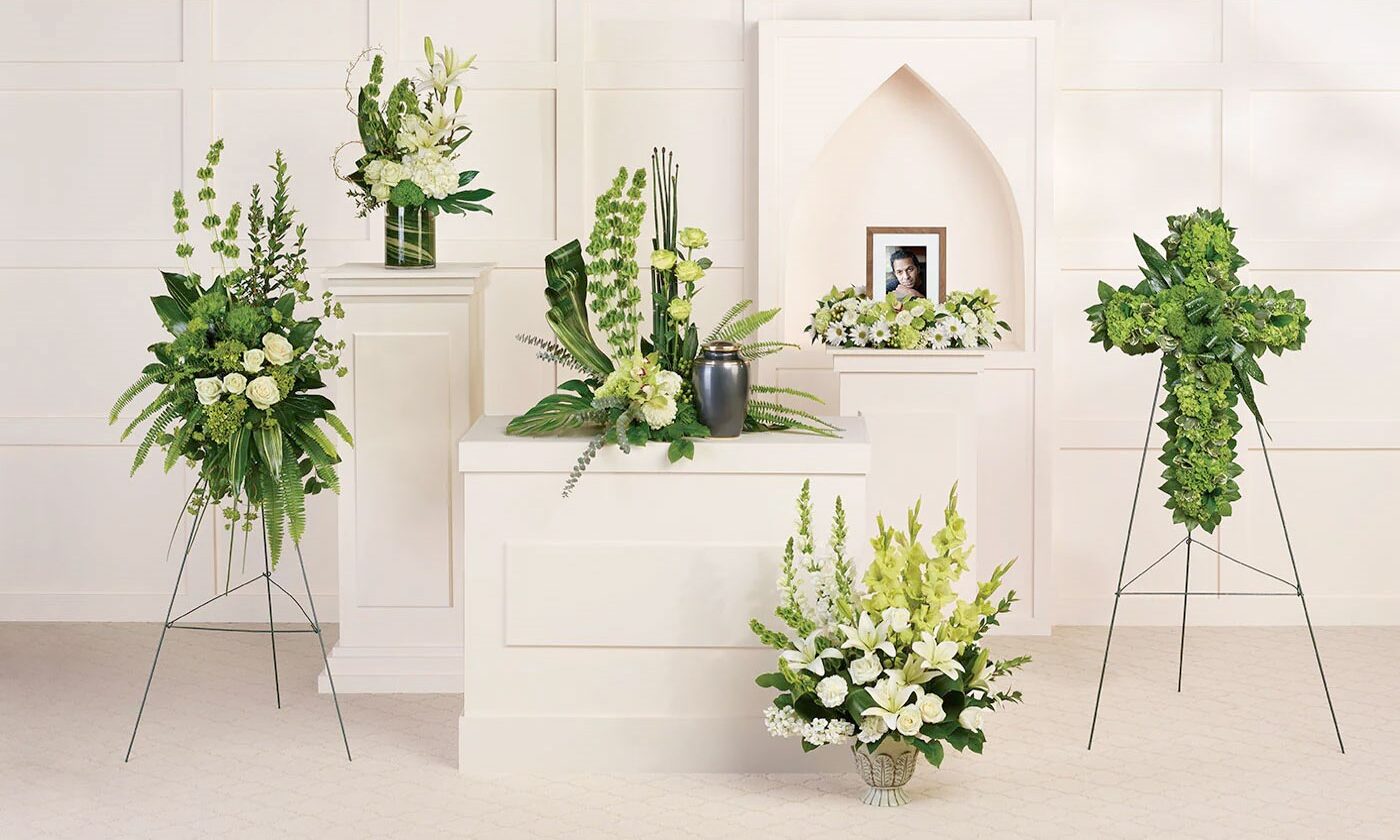 A white room with several different vases of flowers.