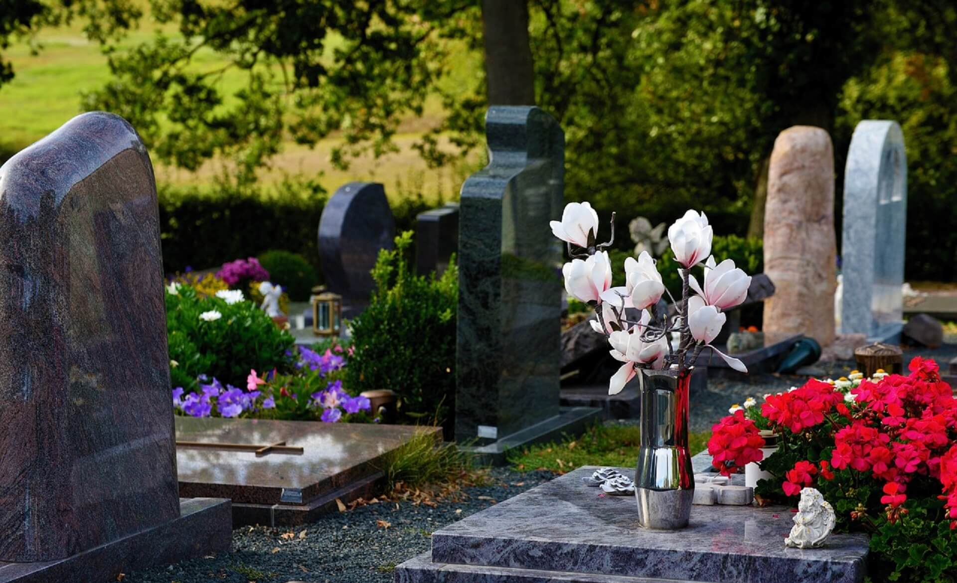 A vase of flowers on top of a grave.