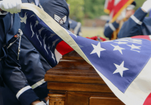 A person in blue and white holding an american flag.