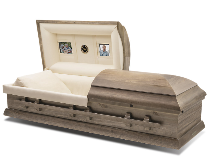 A wooden casket with two windows and a white pillow.